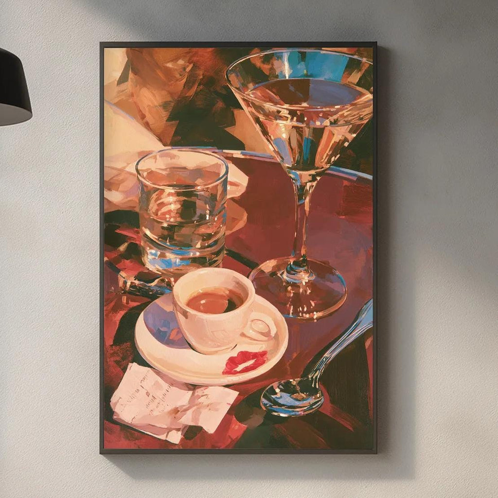 a kitchen counter with various items, including a framed painting of a glass of wine, a coffee cup, a wine glass, a cutting board, and some kitchen accessories.