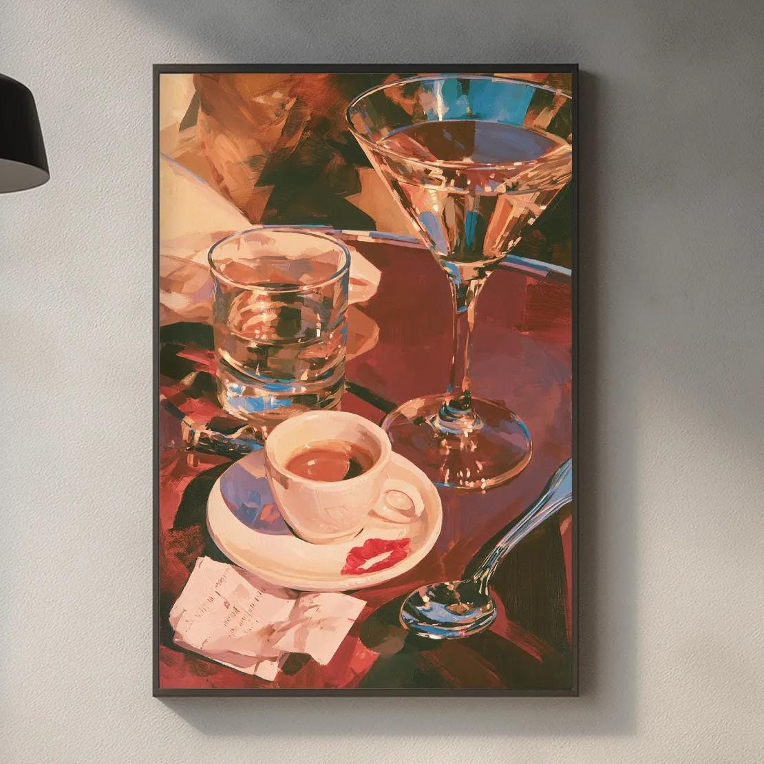 a kitchen counter with various items, including a framed painting of a glass of wine, a coffee cup, a wine glass, a cutting board, and some kitchen accessories.