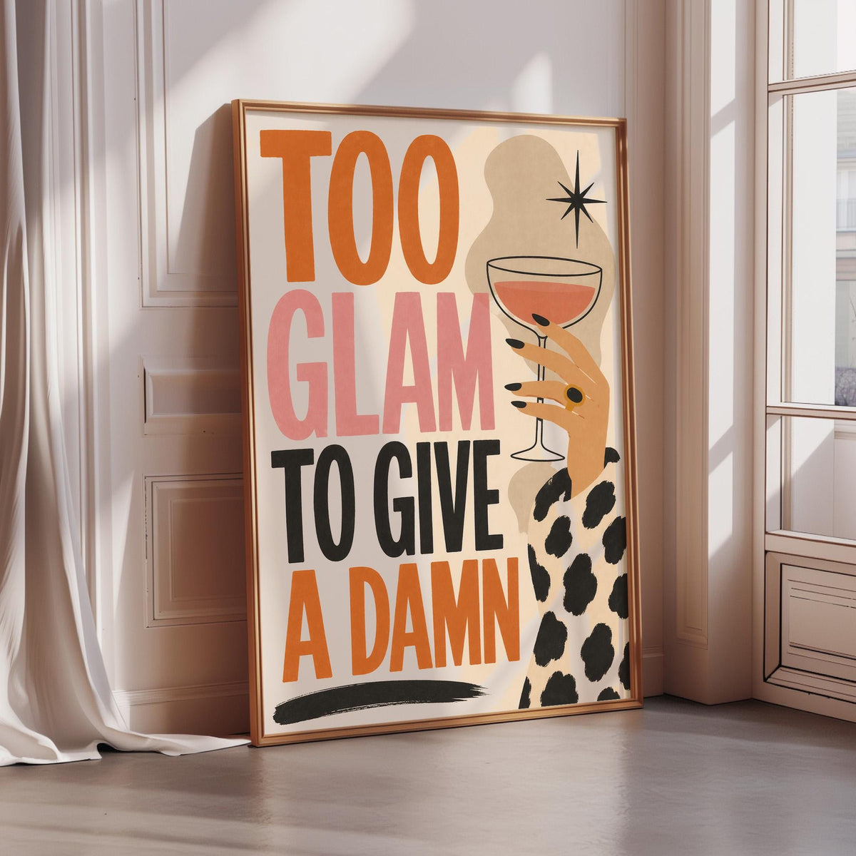 A framed poster with the text "Too Glam to Give a Damn" and an illustration of a hand holding a wine glass.