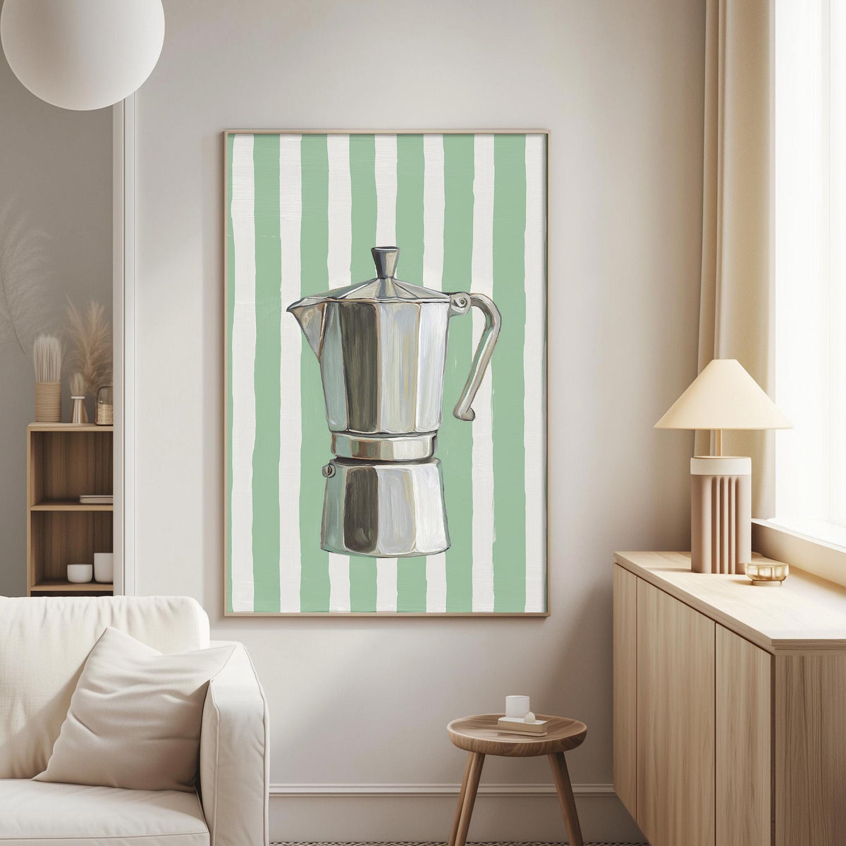 a living room with a white sofa, a wooden side table, and a framed picture of a silver coffee pot with green and white stripes on the wall.