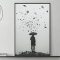 a black and white photograph of a person holding an umbrella, standing on a rocky surface, with a scattering of small objects around them. The photograph is framed and displayed on a wall above a gray couch, which is decorated with various items such as vases, books, and a coffee table.