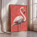 A framed photograph of a flamingo standing on a red and white zebra print background.