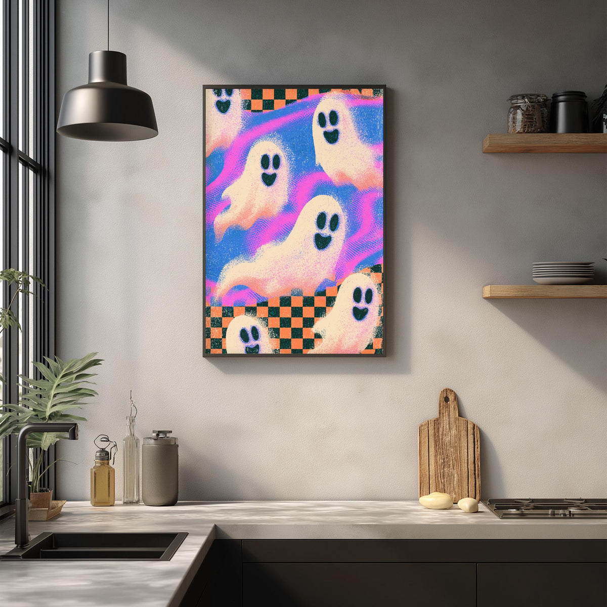 a kitchen counter with a framed poster of colorful ghost figures hanging on the wall above it.