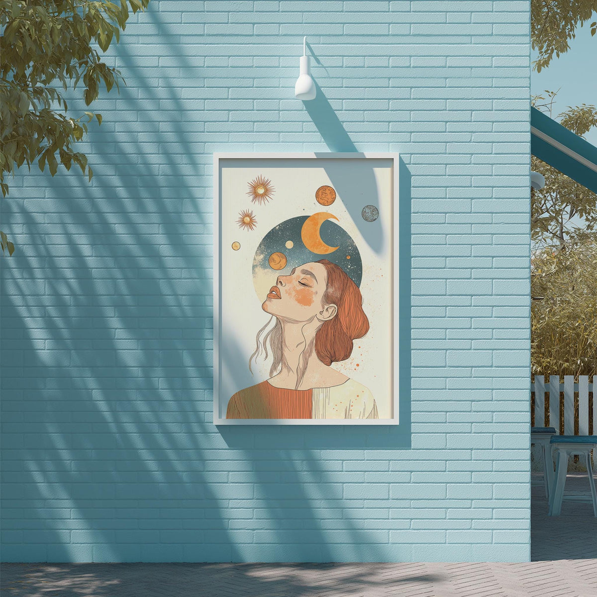 a framed illustration of a woman with a crescent moon and stars above her head, set against a blue brick wall.