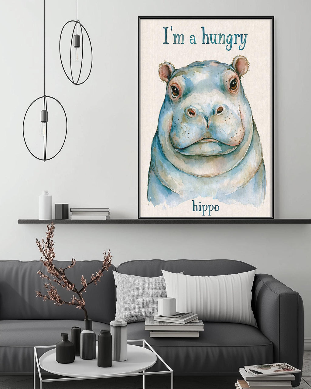a large framed poster of a hippopotamus with the text "I'm a hungry hippo" on it, hanging on a wall above a gray couch in a living room setting.