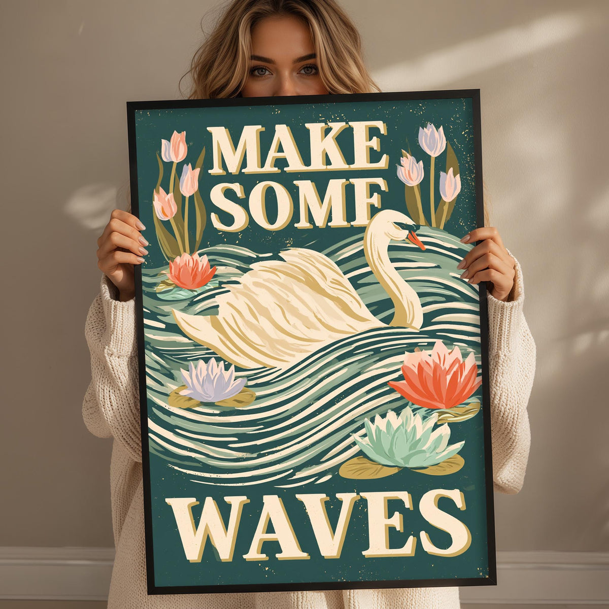 A woman is holding up a framed poster with a swan and flowers, and the text "MAKE SOME WAVE" is displayed on the poster.
