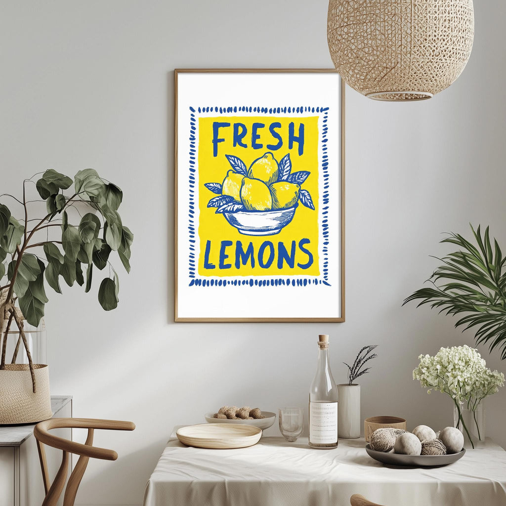 a framed poster with the text "FRESH LEMONS" on it, hanging on a wall above a dining table with various items on it.