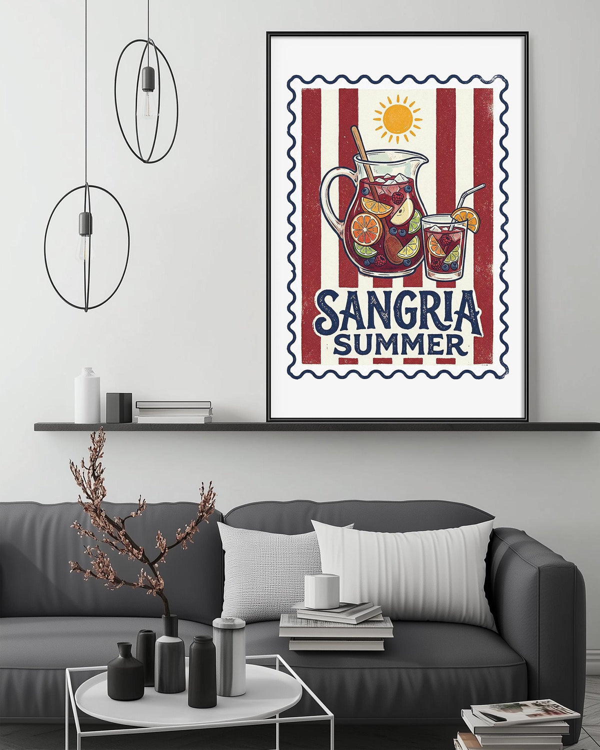 a framed poster of a pitcher of Sangria, a summer drink, hanging on a wall above a gray couch with a coffee table in front of it.