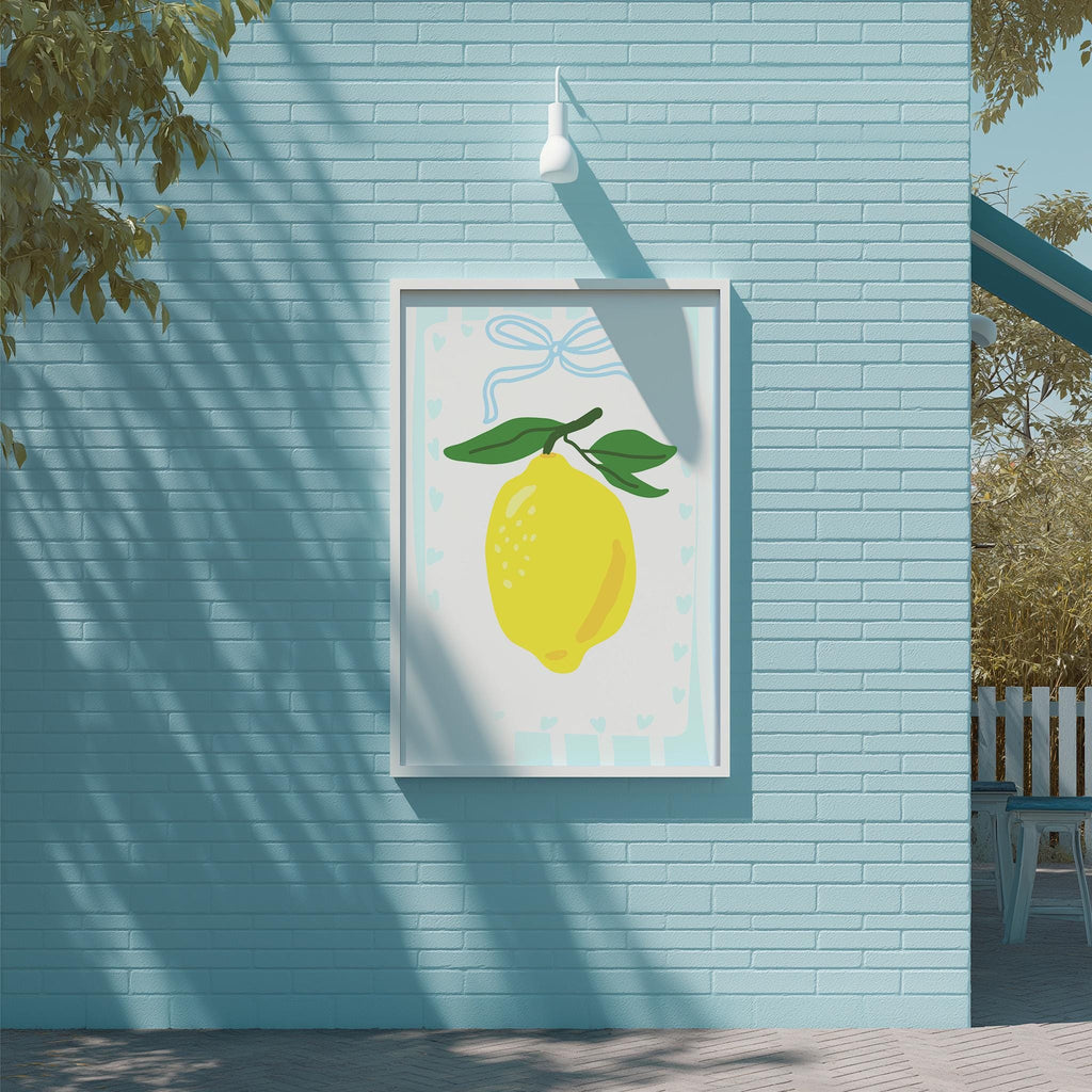 A framed illustration of a lemon is displayed on a blue brick wall, with a white light fixture above it.