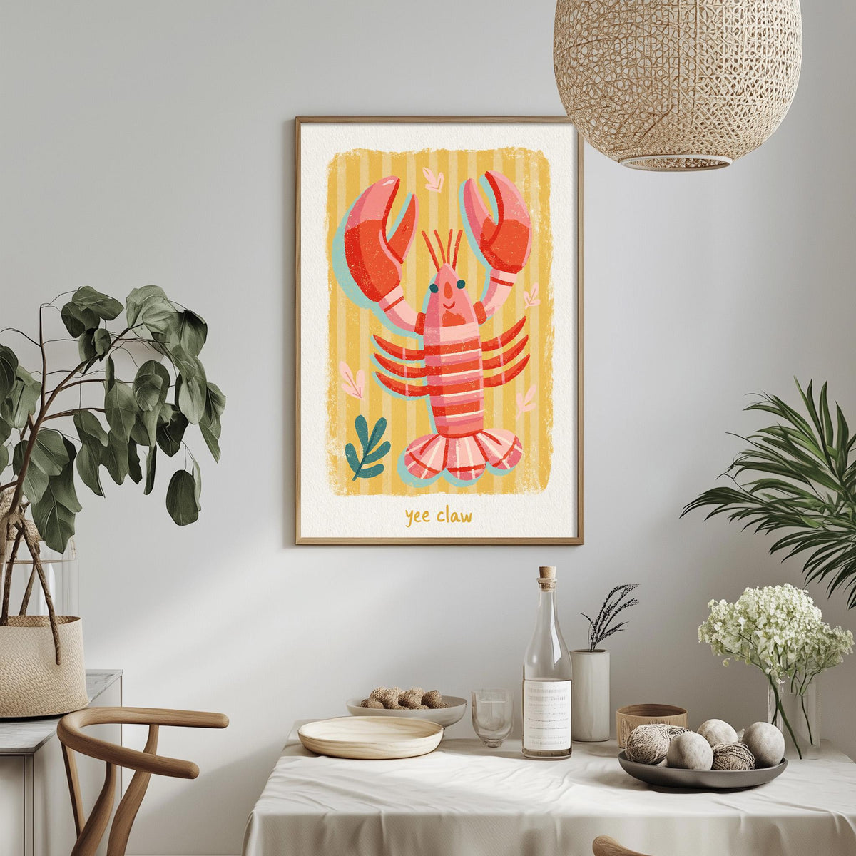 a framed illustration of a lobster on a wall, with a dining table and chairs in the foreground.
