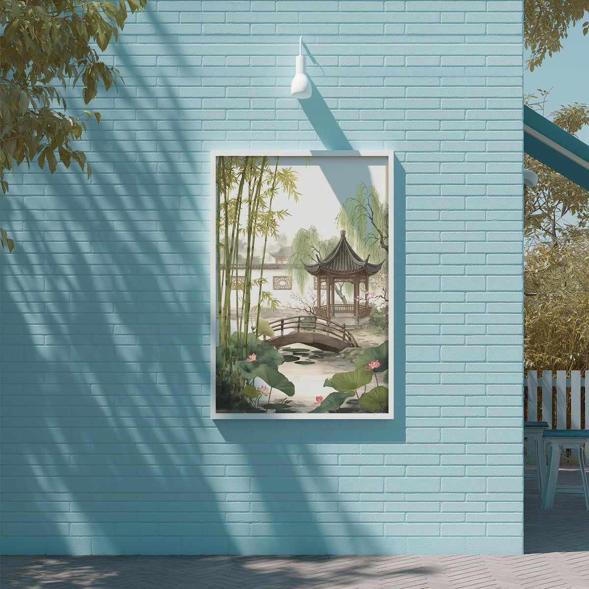A framed painting of a serene garden scene with a traditional Chinese pavilion, bamboo trees, and a pond is displayed on a light blue brick wall.