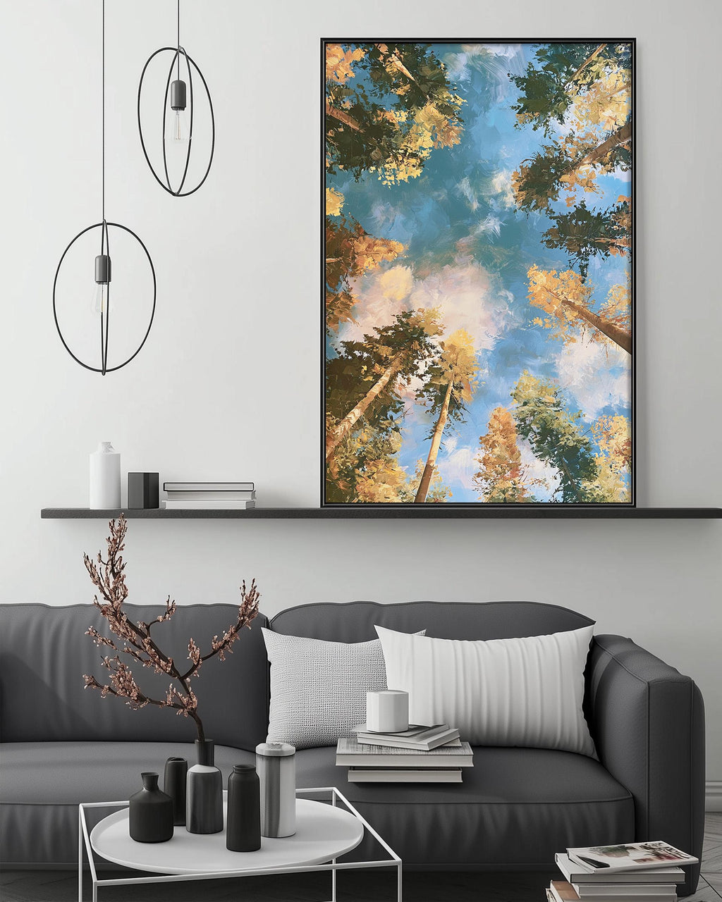a modern living room with a gray sofa, a coffee table, and a large framed painting of a forest scene hanging on the wall above the sofa.
