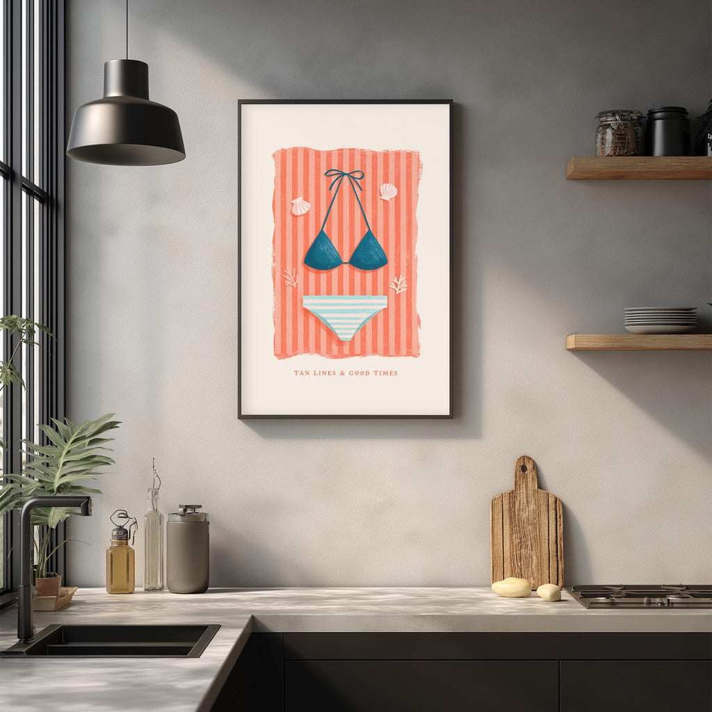 a kitchen counter with various items, including a framed poster of a bikini, a wooden cutting board, and a potted plant.
