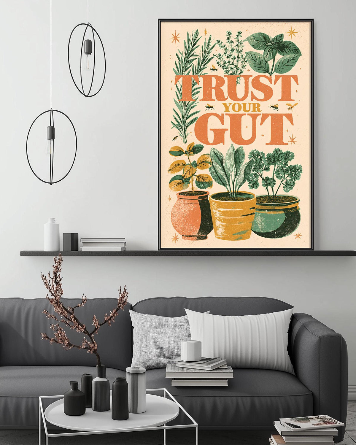 a living room with a gray couch, a coffee table, and a large framed poster with a plant illustration and the text "Trust Your Gut" displayed on the wall above the couch.
