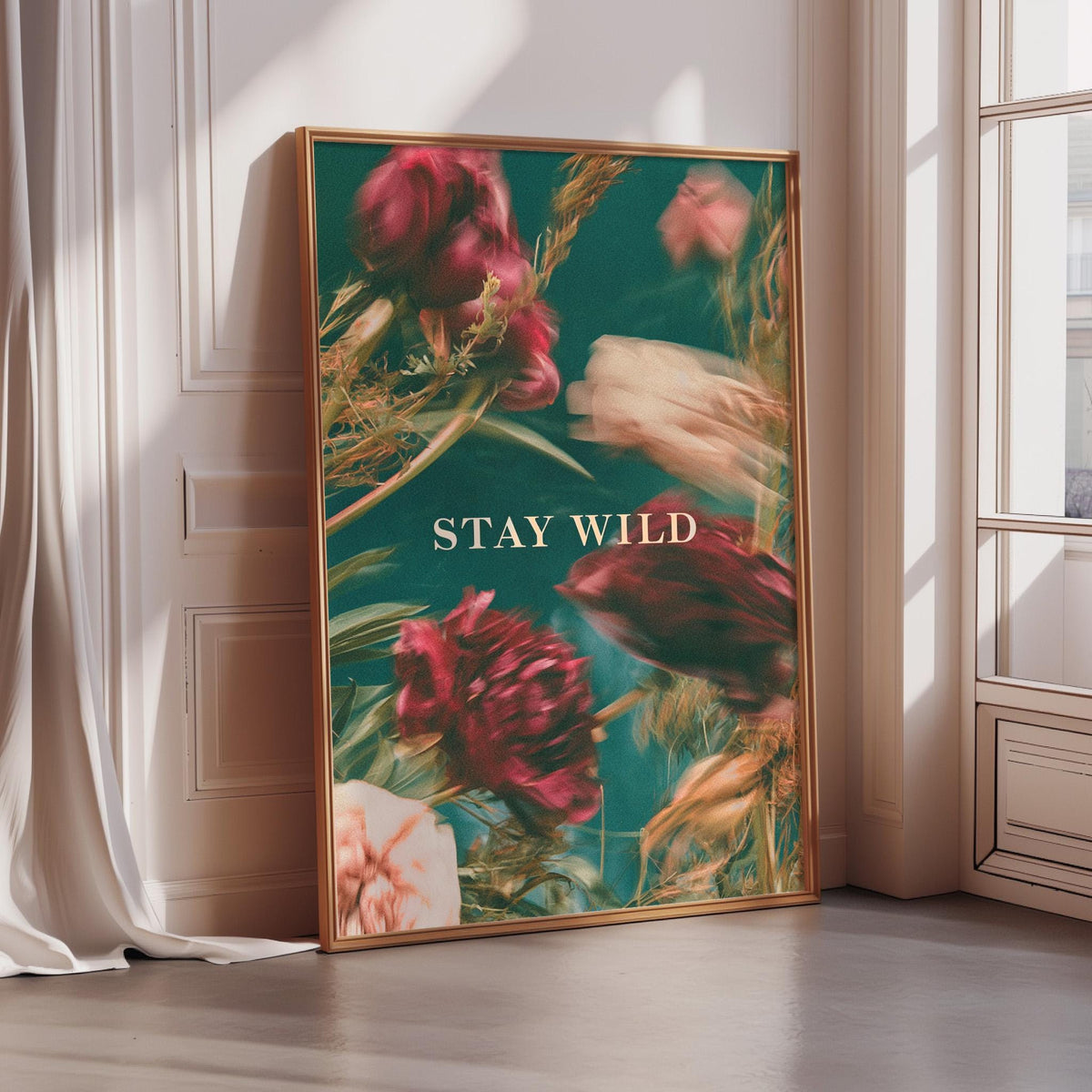 a framed poster with a vibrant floral design and the text "STAY WILD" prominently displayed.