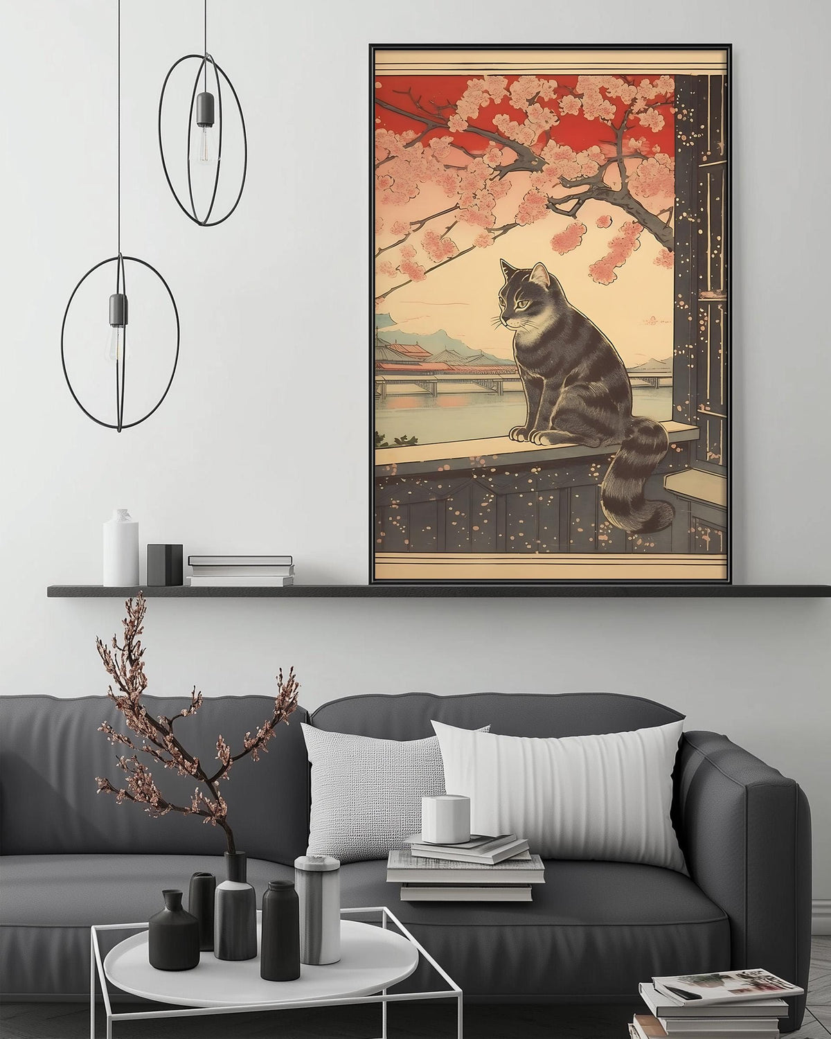 a large framed print of a cat sitting on a ledge, with a cherry blossom tree in the background. The cat is depicted in a realistic style, with intricate details and vibrant colors. The print is hung on a wall above a gray couch, which is adorned with various decorative items such as vases, books, and a potted plant. The overall scene creates a cozy and inviting atmosphere in the living room.