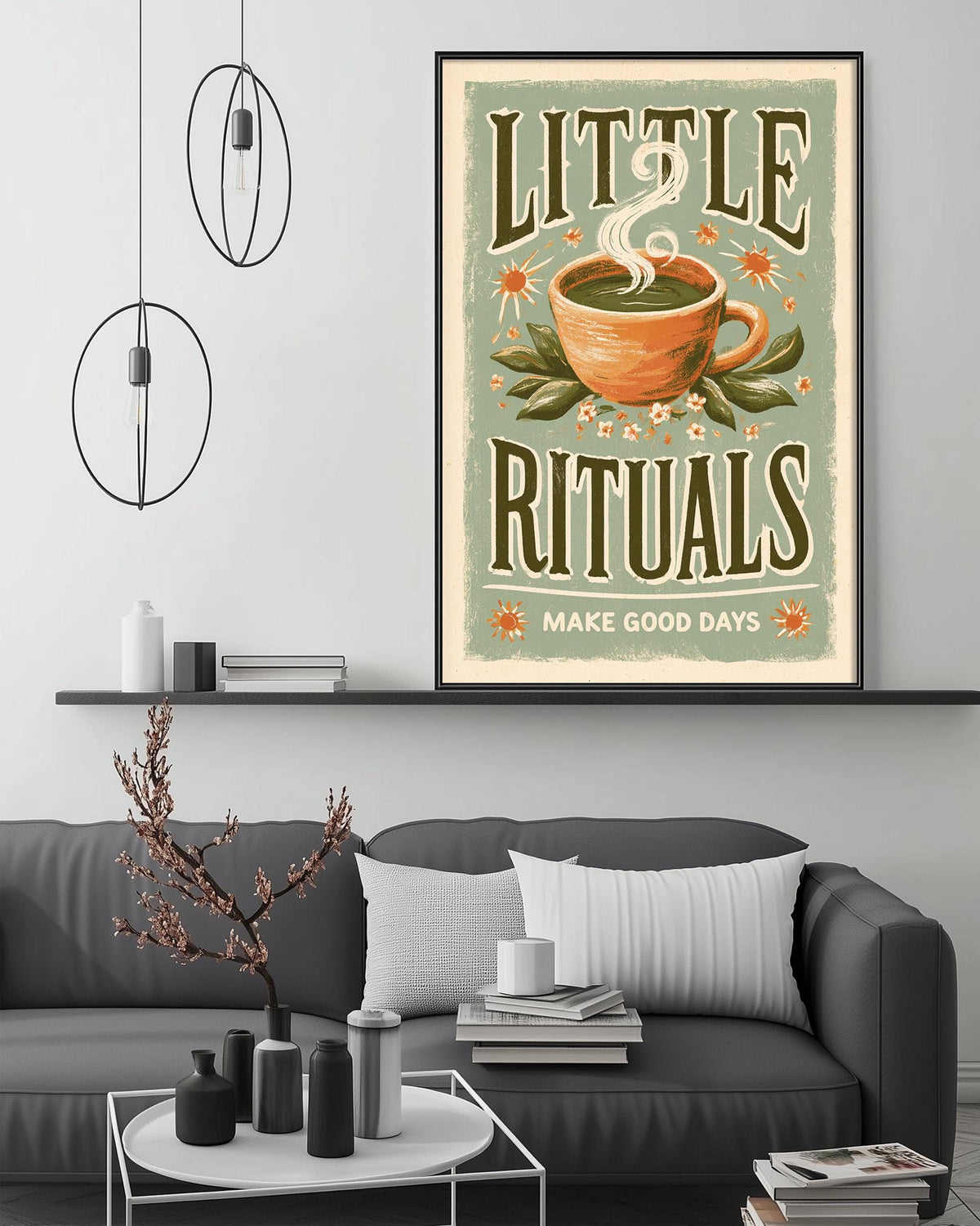 a cozy living room with a gray couch, a coffee table, and a framed poster on the wall. The poster has a warm, inviting design with a cup of tea and flowers, and it reads "Little Rituals" and "Make Good Days".