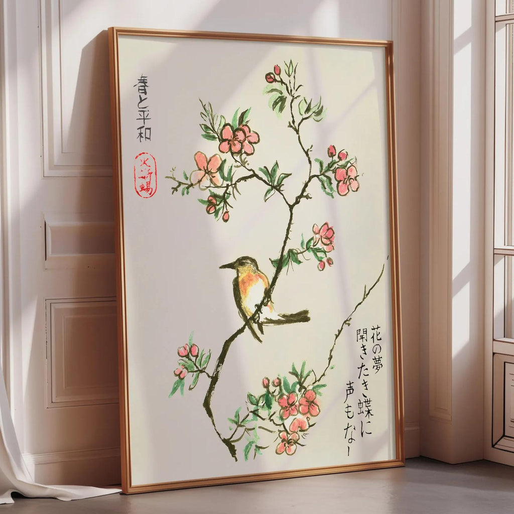 A framed painting depicting a bird perched on a branch with pink flowers, placed on a wooden floor in a room with a window.