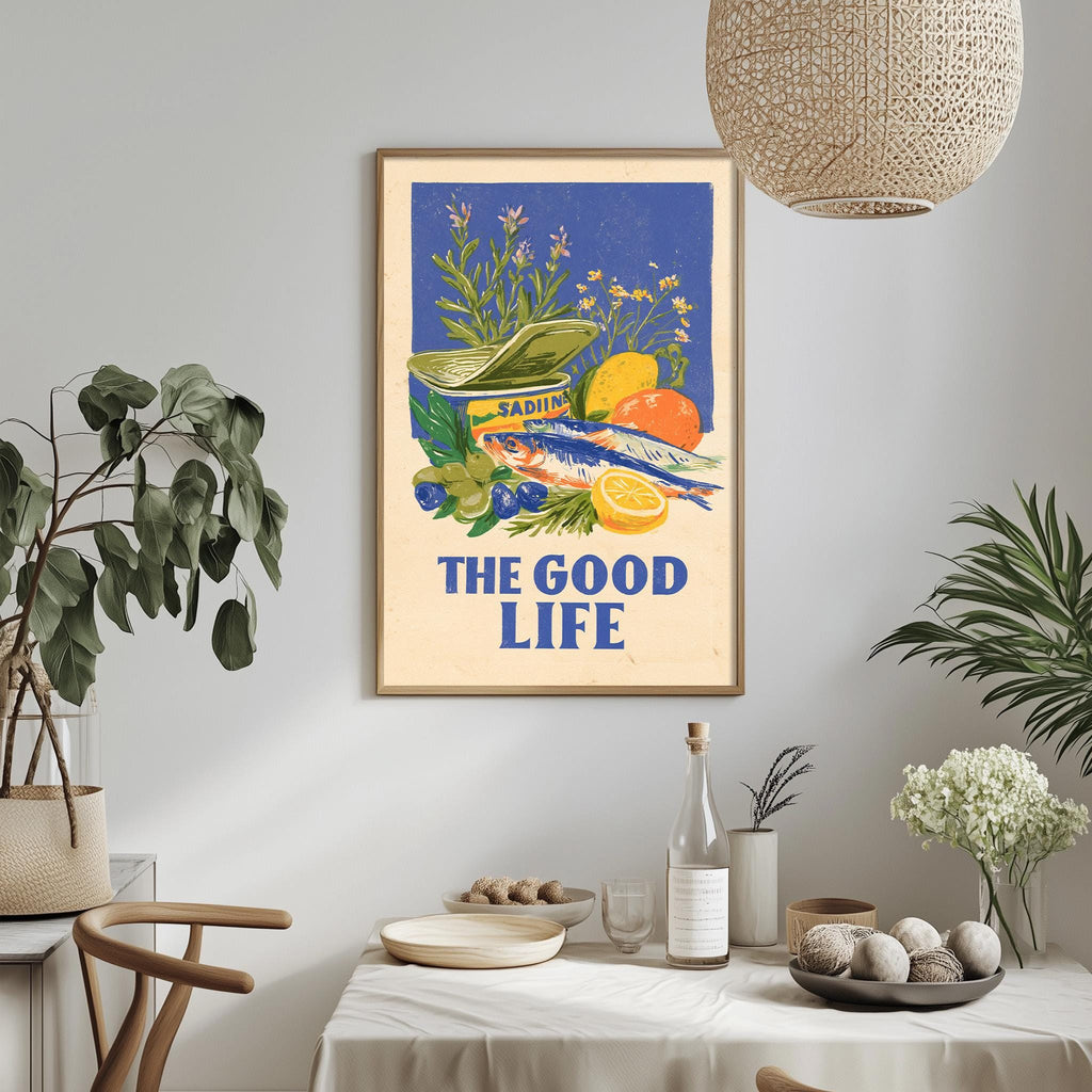 a framed poster with a vibrant illustration of fruits and vegetables, including a fish, hanging on a wall above a dining table with various items on it.