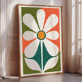 a large, colorful abstract painting of a flower with a green stem and white petals, displayed on a wall in a room with a window.