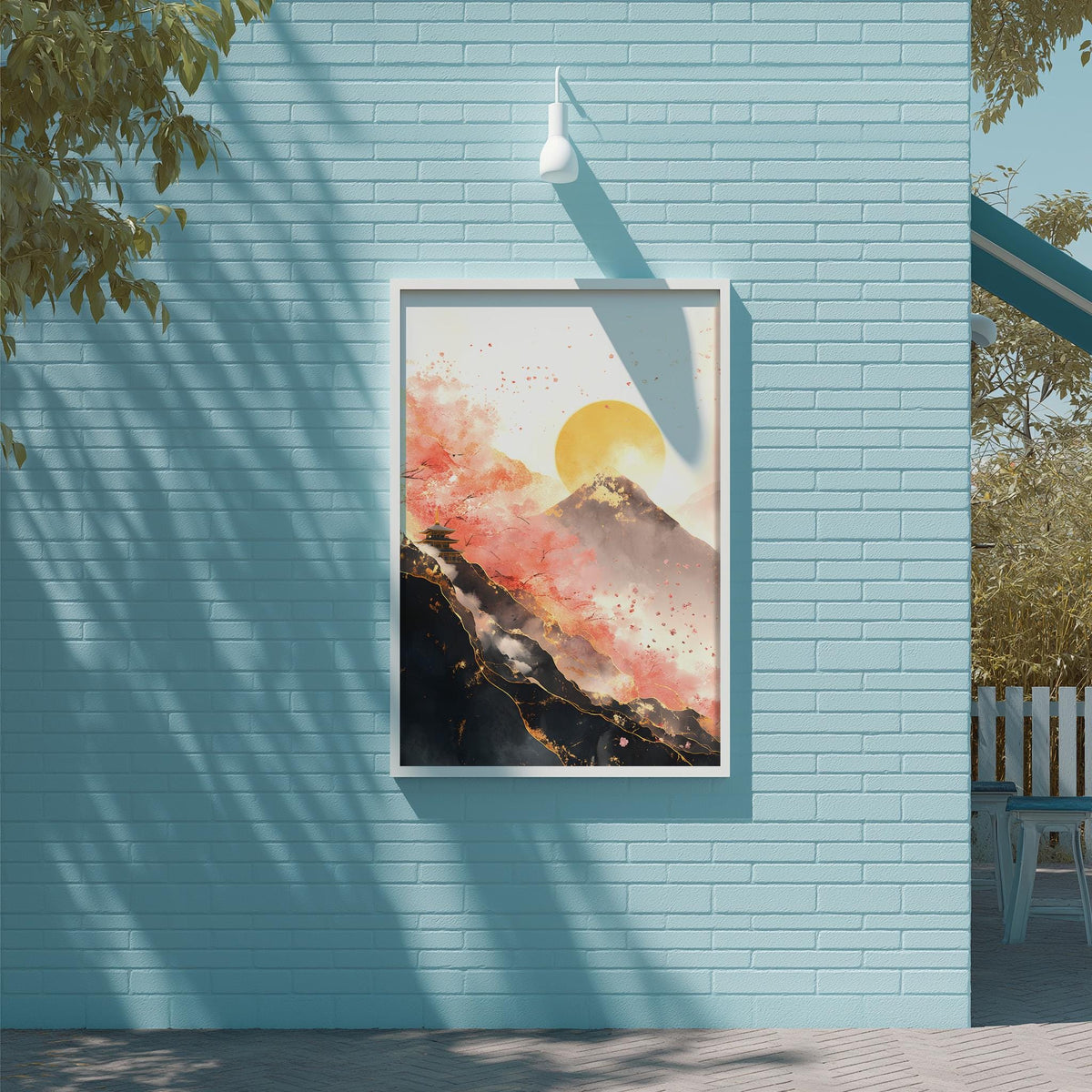 a framed painting of a mountain landscape with a sun in the sky, hanging on a blue brick wall.