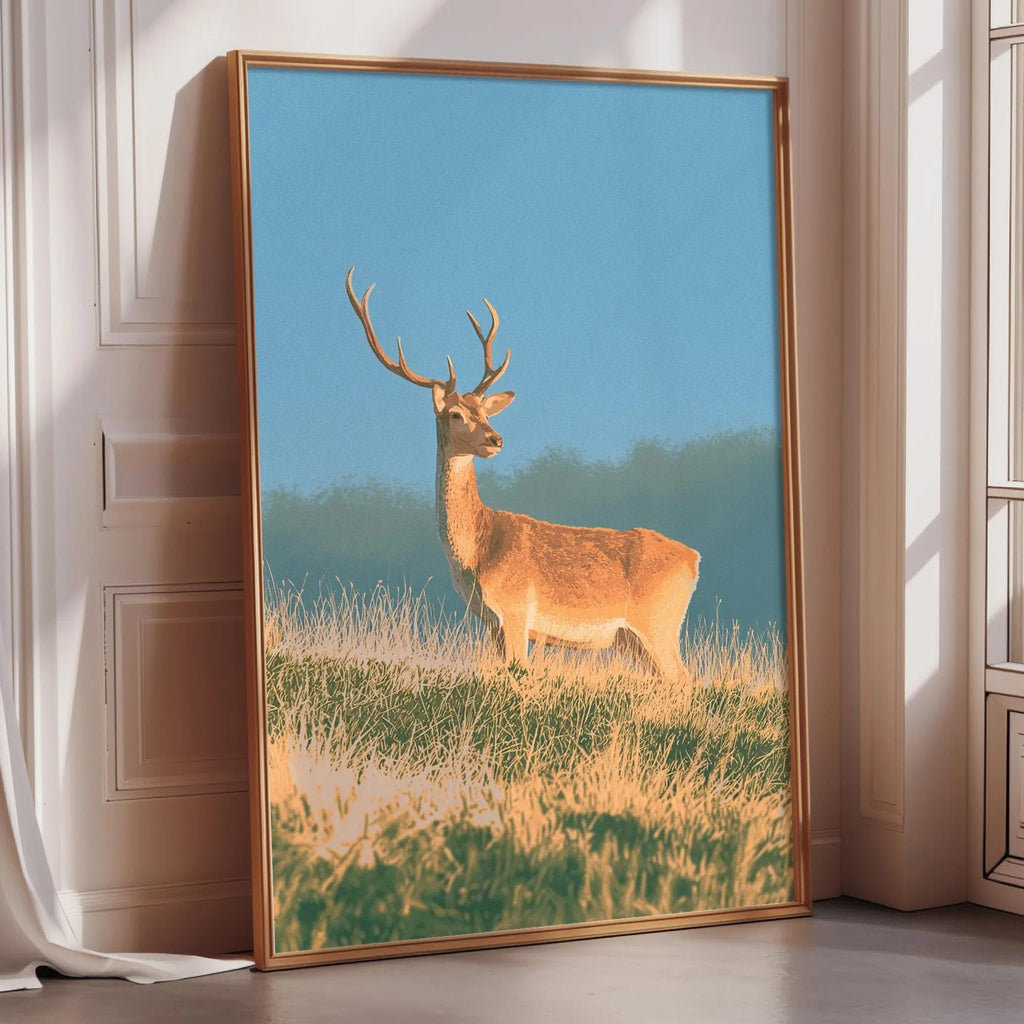 A framed photograph of a deer standing in a grassy field against a blue sky.