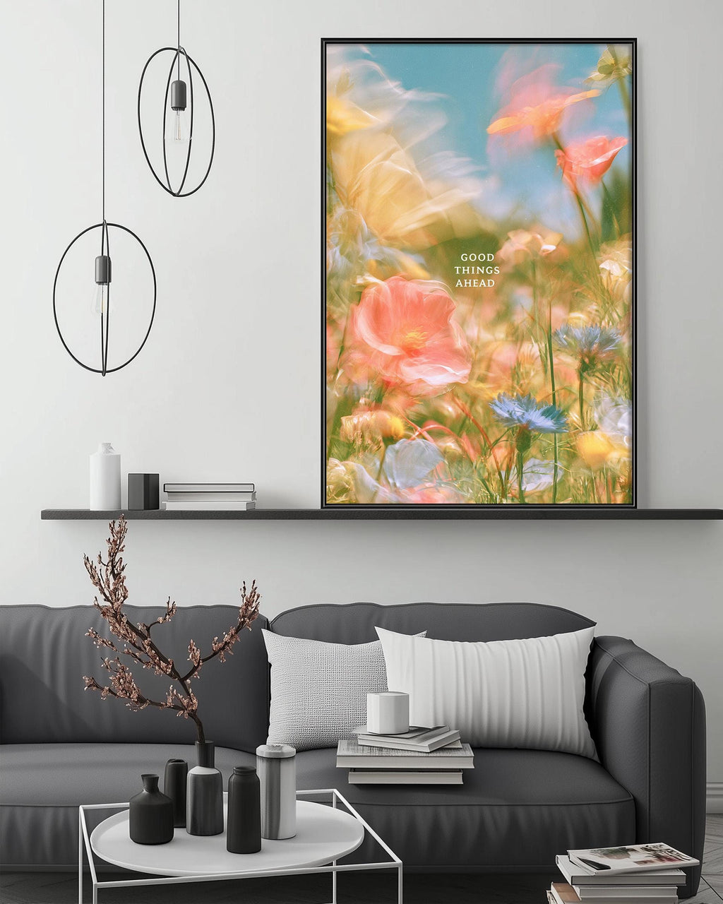 a large, colorful painting of flowers hanging on a wall above a gray couch in a living room setting.