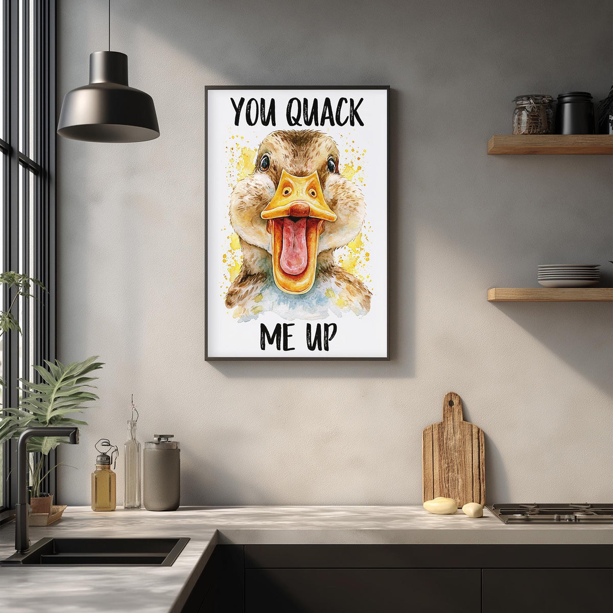 a kitchen counter with various items such as a cutting board, a soap dispenser, and a potted plant. Above the counter, there is a framed poster with a duck's face and the text "YOU QMACK ME UP" displayed on the wall.