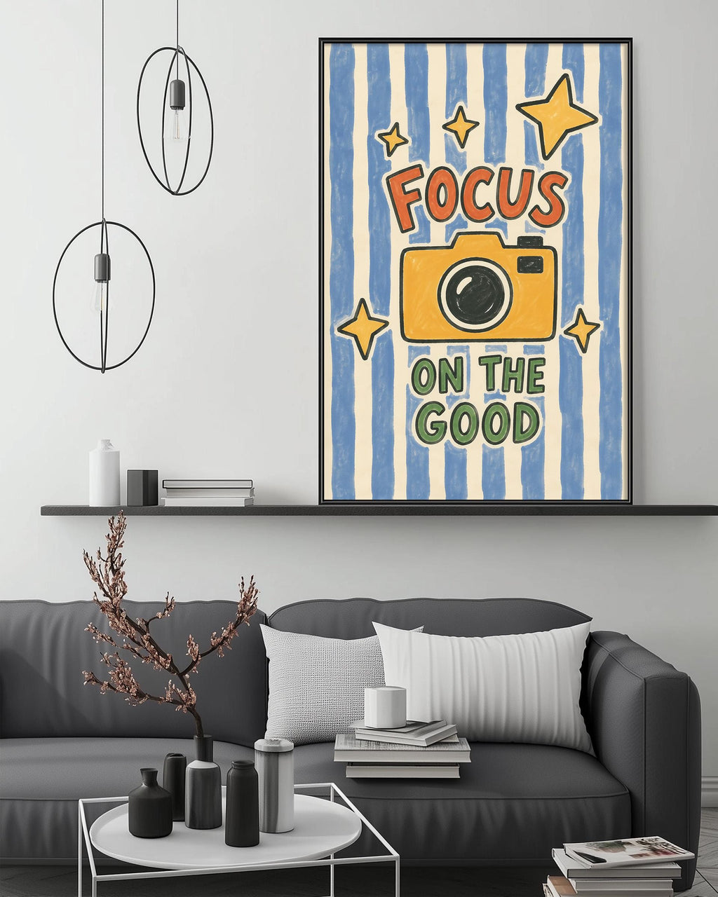 a living room with a gray couch, a coffee table, and a framed poster with a camera and the text "Focus on the good" on it.
