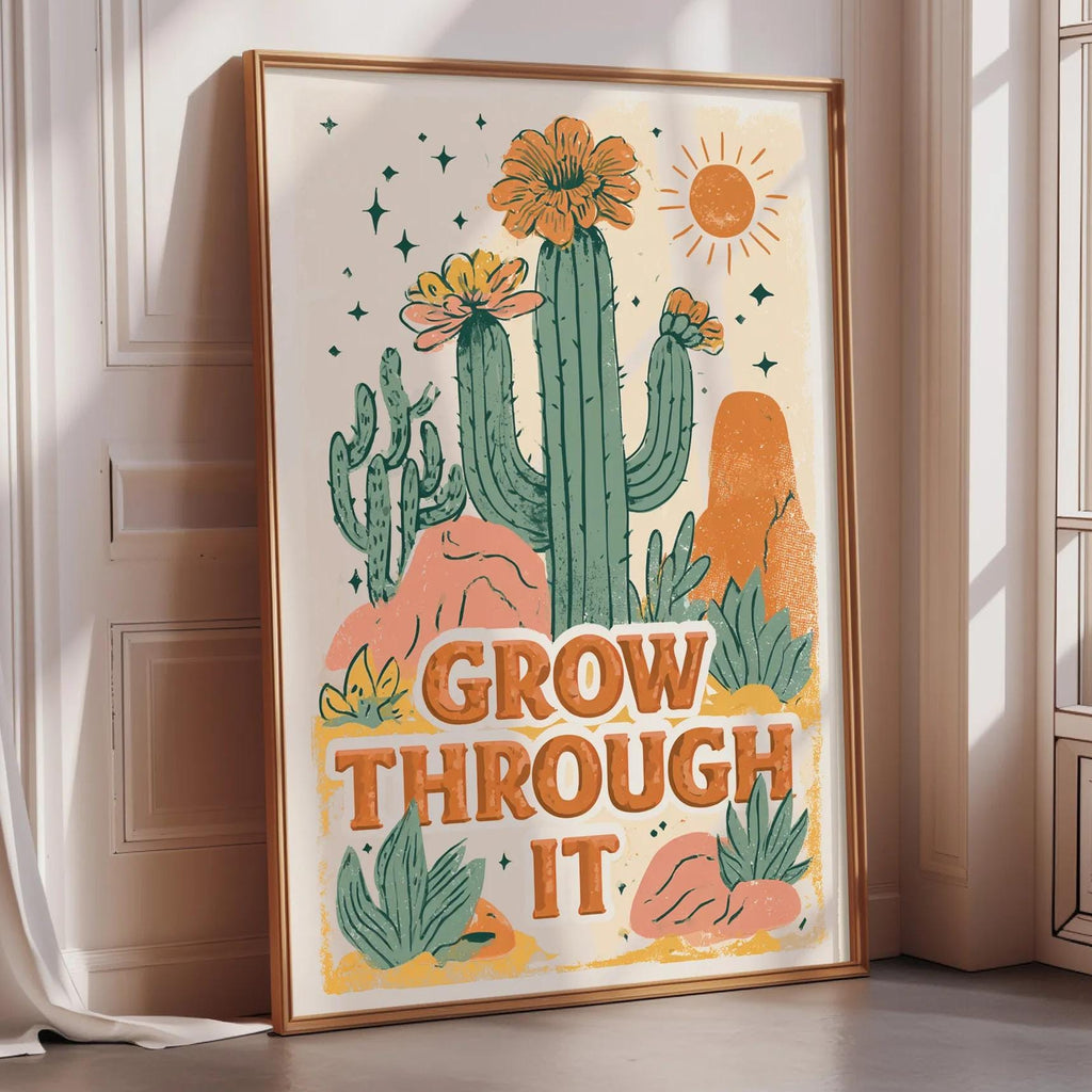 a framed poster with a desert-themed illustration and the text "Grow Through It" written on it.