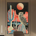 a modern office space with a large wall-mounted artwork depicting a desert landscape with a cactus and a large owl. The office has a wooden desk, a chair, and a bookshelf with various books and decorative items. The overall design and decor create a stylish and contemporary atmosphere.