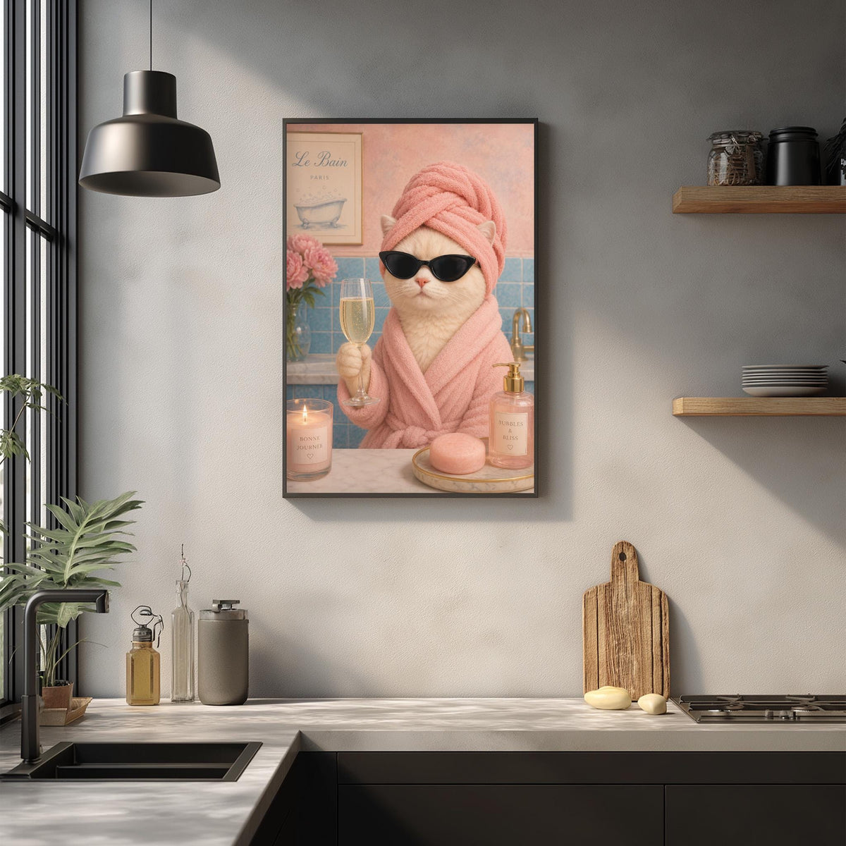 A framed image of a cat wearing a pink bathrobe and sunglasses, holding a glass of wine, in a bathroom setting with a sink, countertop, and various bathroom items.