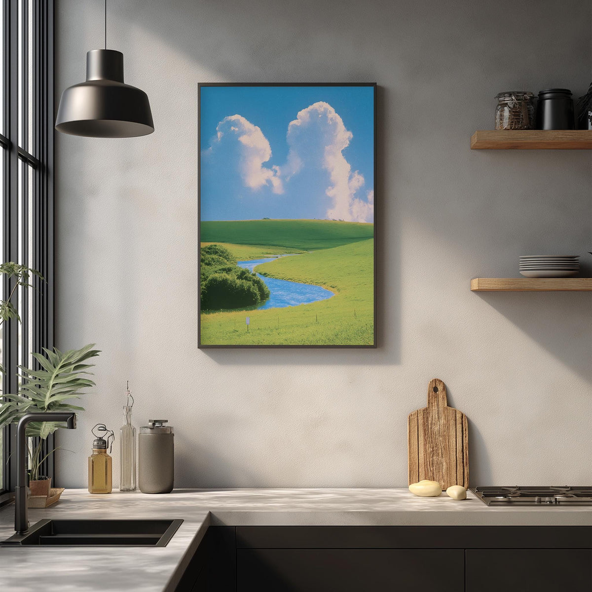 a kitchen counter with various kitchen items, including a cutting board, a sink, and a plant. Above the counter, there is a framed picture of a green field with a river, creating a serene and peaceful atmosphere in the kitchen.