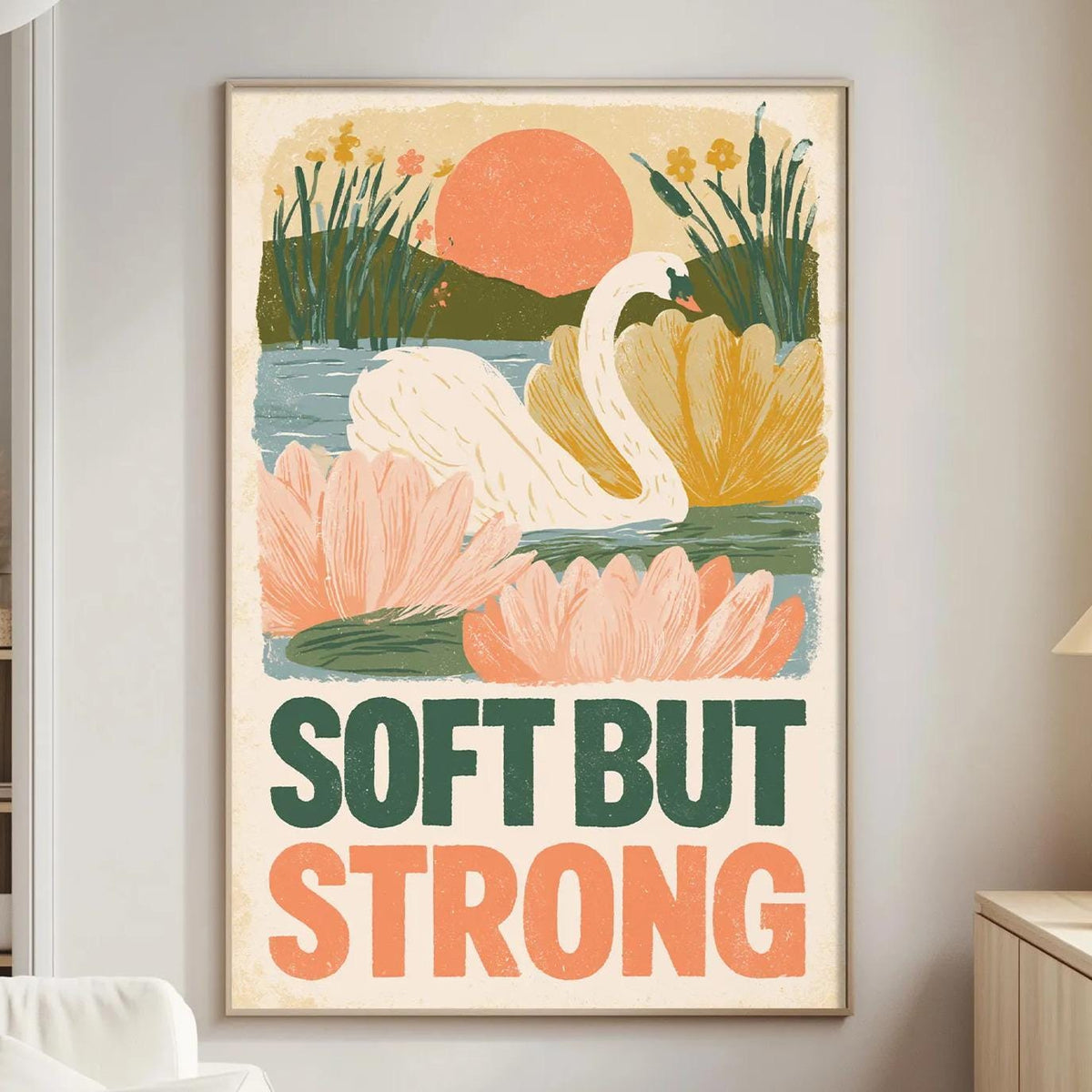 a poster with a colorful illustration of a swan and flowers, along with the text "Soft but strong" displayed prominently on the poster.