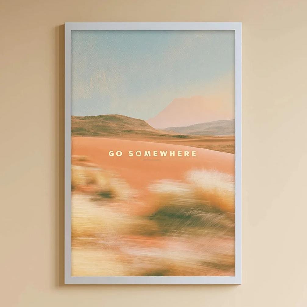 A cozy children's room with a white bookshelf, a plush rabbit, and a colorful toy box filled with toys. A framed poster with the text "GO SOMEWHERE" hangs on the wall, and a toy train is visible on the shelf.