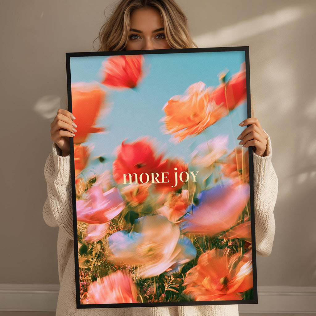 A woman holding a framed poster with a vibrant floral design.