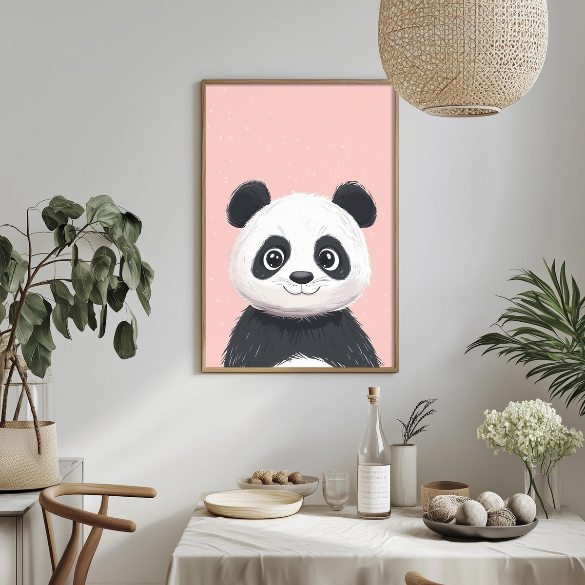 a framed illustration of a panda bear on a pink background, hanging on a wall above a dining table with various decorative items and plants.