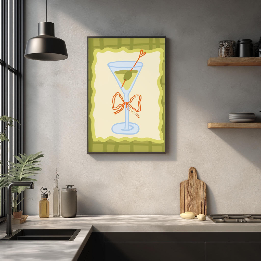 a kitchen counter with various items, including a framed picture of a martini glass, a wooden cutting board, and a potted plant.