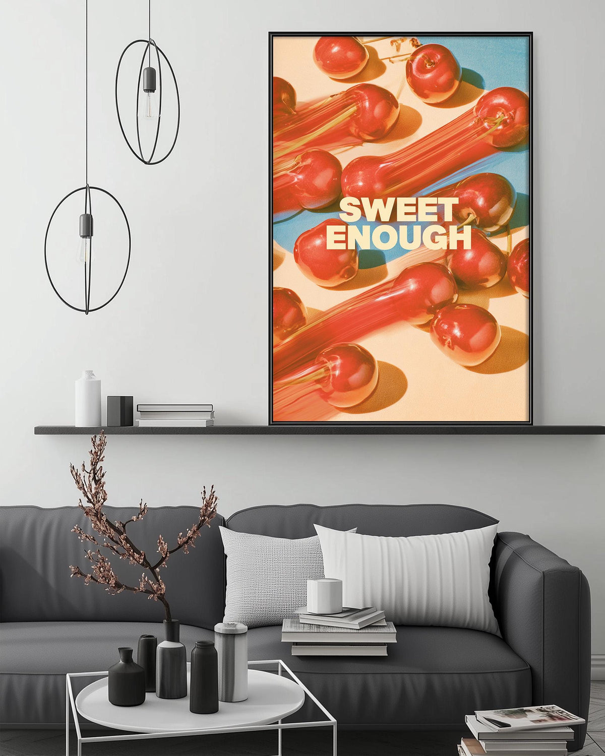 a modern living room with a gray sofa, a coffee table, and a large framed poster of red peppers hanging on the wall.
