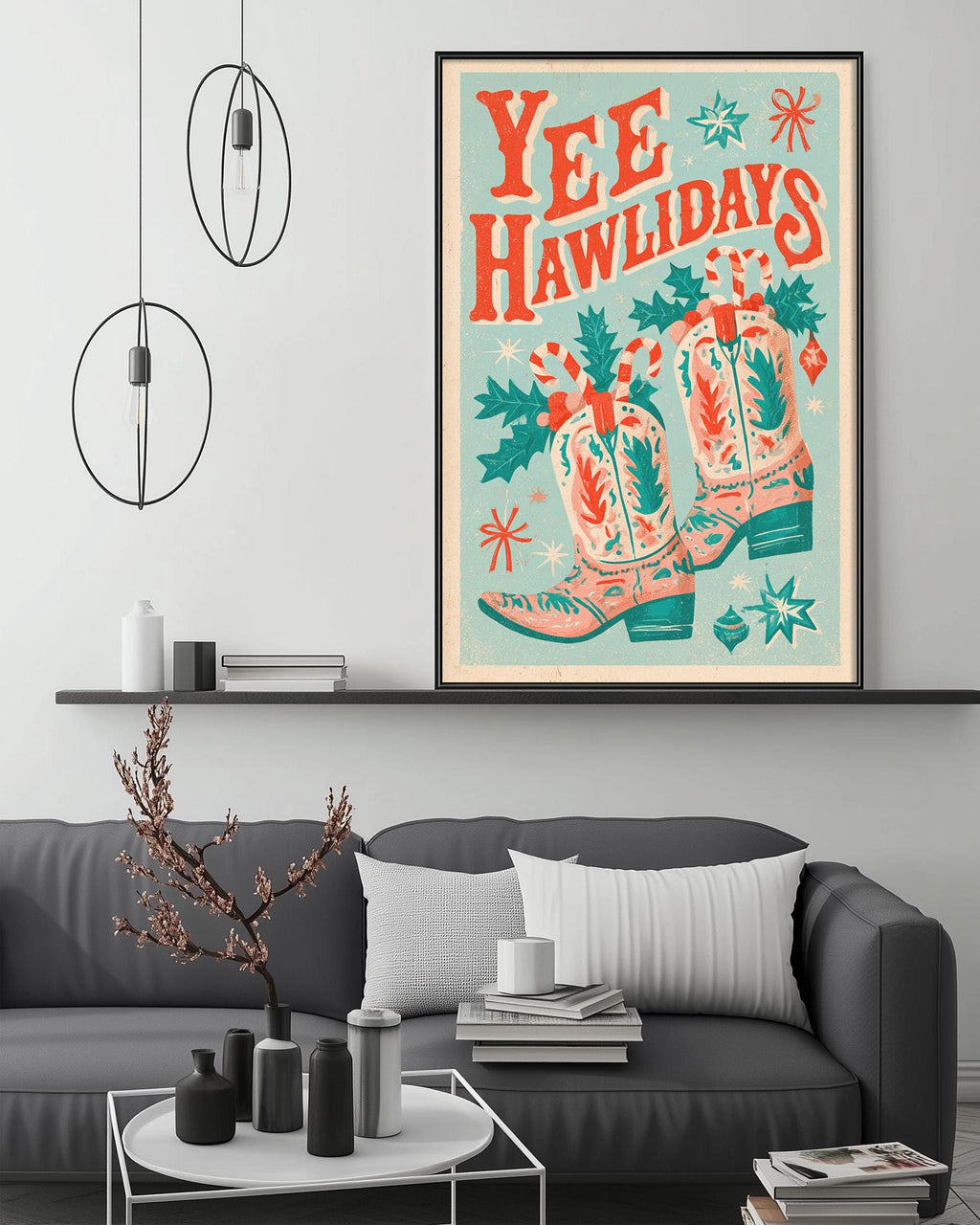a cozy living room with a gray couch, a coffee table, and a framed poster of cowboy boots and holiday decorations hanging on the wall.
