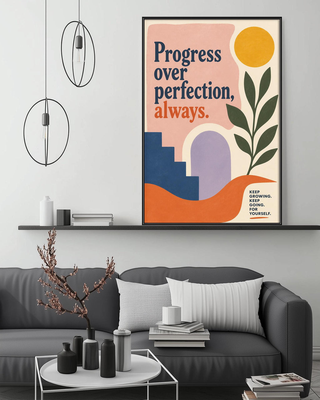a modern living room with a gray sofa, a coffee table, and a framed poster on the wall. The poster has a colorful design with a sun, a plant, and a staircase, and it reads "Progress over perfection, always."