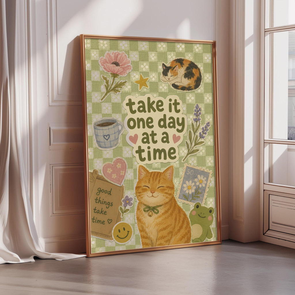 The image is a framed poster with a cat, flowers, and other decorative elements, along with the text "Take it one day at a time".