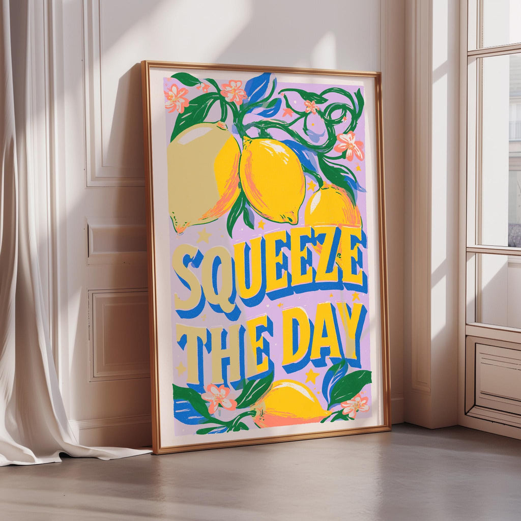 A framed poster with a vibrant design featuring lemons and the text "SQUEEZE THE DAY" is displayed on a wall.