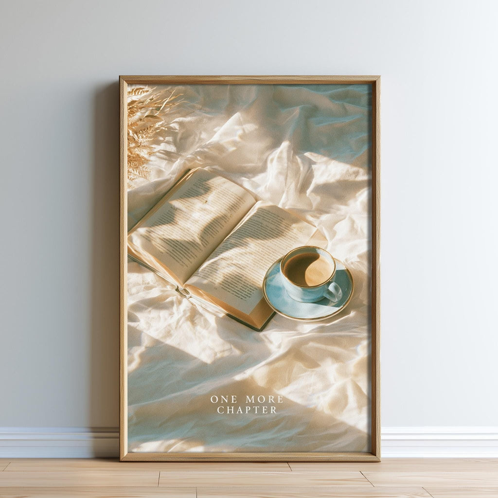 A framed poster with an open book and a cup of coffee on a bed, with a text overlay that reads "ONE MORE CHAPTER".