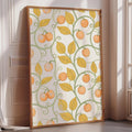 a large framed poster with a repeating pattern of orange and green leaves and small orange fruits, creating a vibrant and lively design.