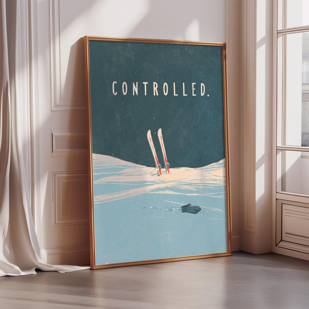 a framed poster with a skiing scene, depicting a pair of skis on a snowy slope with the word "controlled" written on the poster.