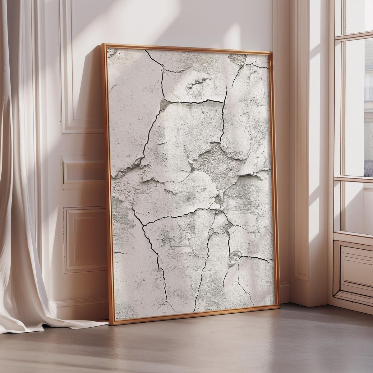 a large, framed picture of a cracked wall, which is placed in a corner of a room with a window.