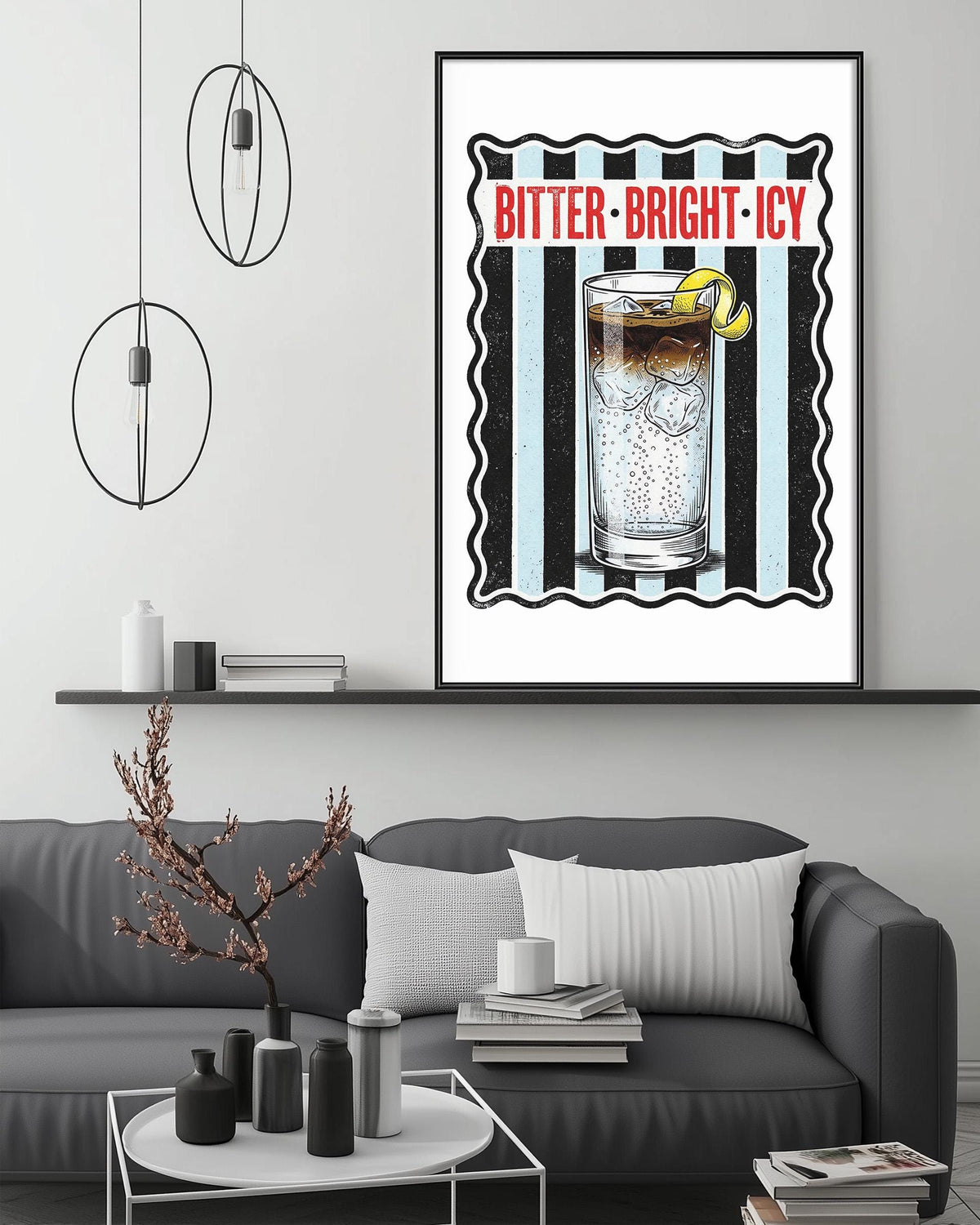 a framed poster of a glass with a lemon slice, accompanied by the text "BITTER-BRIGHT-ICY" in bold red letters. The poster is displayed on a wall above a gray couch, which is decorated with various items such as a potted plant, vases, and books.