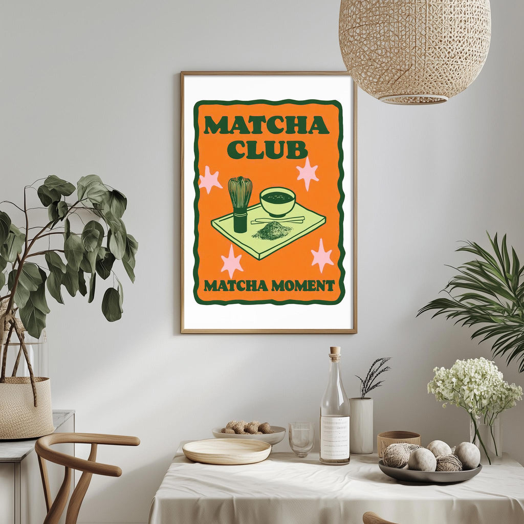 a framed poster with a vibrant design hanging on a wall, depicting a table set with various items, including a bowl, a plant, and a bottle.