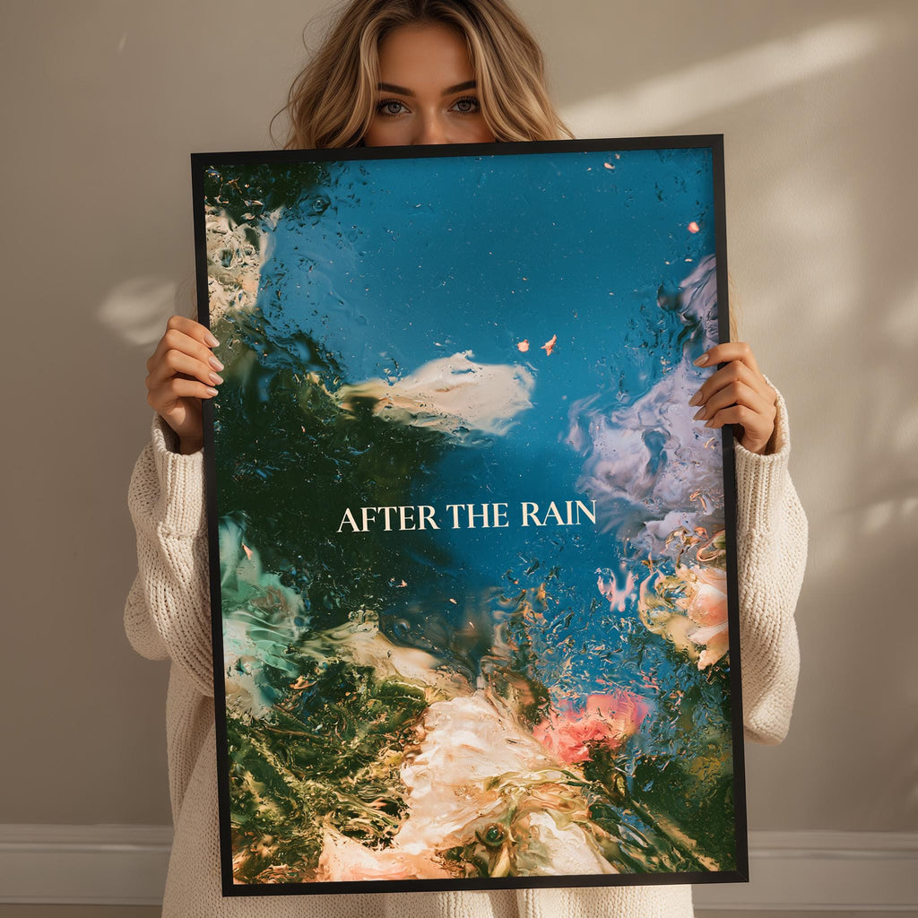 A woman holding a framed poster with a colorful abstract design, including elements like water, flowers, and clouds.